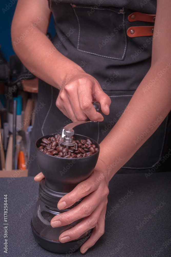Young white-skinned Latina woman making hot drink, American-style coffee with milk and water in a coffee machine in the comfort of her home. She is happy and content.