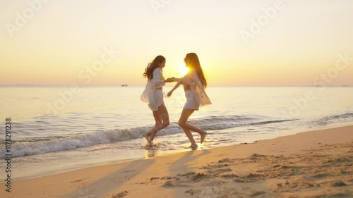 Happy woman travel nature ocean on summer beach holiday vacation. Group of Asian women friend enjoy and fun outdoor lifestyle dancing and playing in the sea together on tropical island beach at sunset