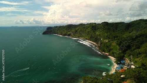 Aerial drone view of coastline with hills and trees, as well as view of coral cliffs and sea with waves from the ocean in Menganti Beach Kebumen Central Java Indonesia photo