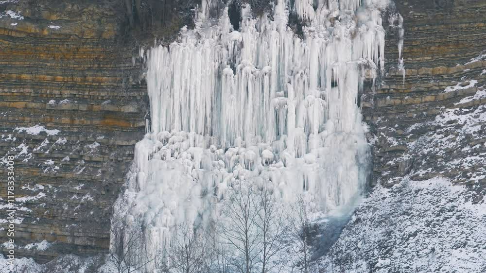 Iced waterfall in Italian alps. Frozen waterfall with ice on a cliff, winter landscape. Iced waterfall in Italian alps. Frozen waterfall with ice on a cliff, winter landscape.