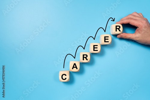 Career progression, illustrated with wooden blocks forming the word CAREER, arranged in ascending order with a growth curve drawn over them on a blue background photo