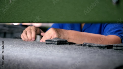 Mature worker cuts details of felt sheet with press machine