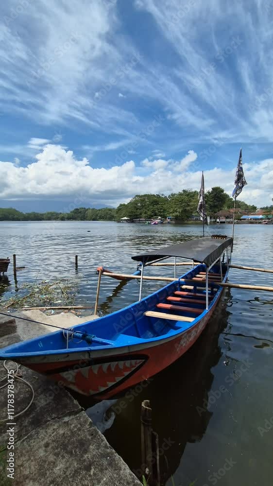 Scenic view of blue wooden boats anchored on the calm Situ Gede Tasikmalaya lake Scenic view of blue wooden boats anchored on the calm Situ Gede Tasikmalaya lake