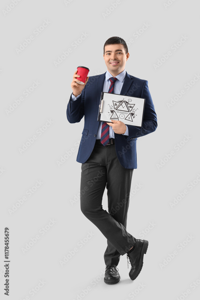 Young businessman with coffee cup and clipboard on light background. Time management concept Young businessman with coffee cup and clipboard on light background. Time management concept