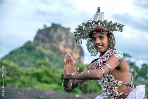 SIGIRIYA, SRI LANKA - JULY 16, 2024 : A Ves Dancer, also known as a Kandyan Dancer or Up Country Dancer performs at Sigiriya in Sri Lanka. In the background stands Sigiriya Rock.