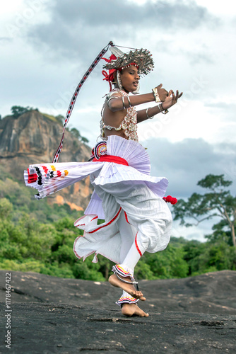 SIGIRIYA, SRI LANKA - JULY 16, 2024 : A Ves Dancer, also known as a Kandyan Dancer or Up Country Dancer performs at Sigiriya in Sri Lanka. In the background stands Sigiriya Rock.