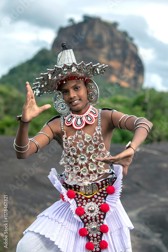 SIGIRIYA, SRI LANKA - JULY 16, 2024 : A Ves Dancer, also known as a Kandyan Dancer or Up Country Dancer performs at Sigiriya in Sri Lanka. In the background stands Sigiriya Rock.