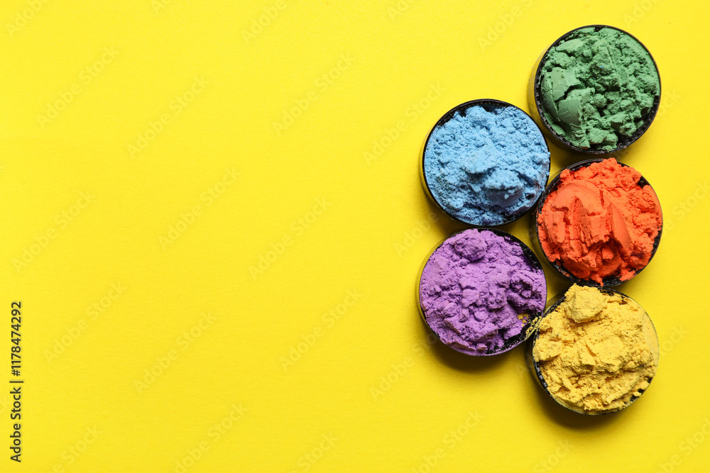 Bowls of powder pigments on yellow background Bowls of powder pigments on yellow background