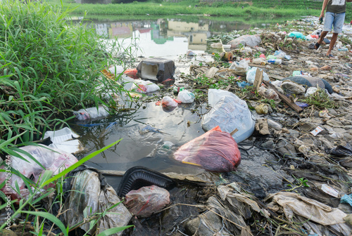 household waste dam in the river. wide angle pile of garbage polluting the river