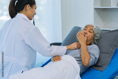 Asian female doctor checking the heart rate of an elderly woman uses a stethoscope to routinely check the health of an elderly woman patient at home. health care concept photo