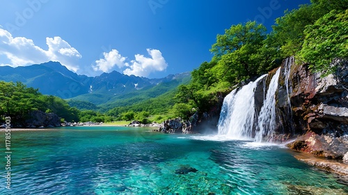 Serene waterfall cascading into a crystal-clear mountain lake, surrounded by lush greenery and majestic mountains under a vibrant blue sky.