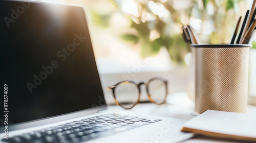 Close up of laptop and eyeglasses on wooden desk in office