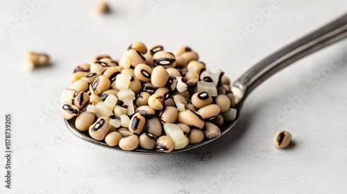 A spoonful of black-eyed peas with diced onions, isolated on a neutral backdrop photo