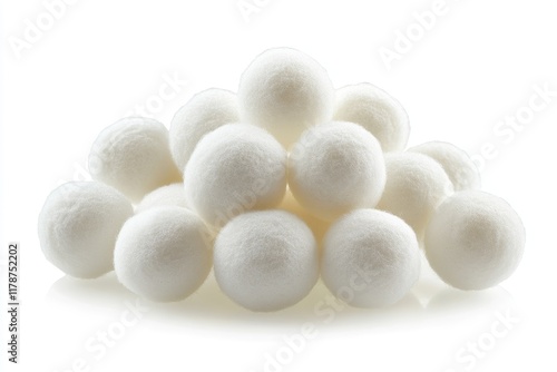 A pile of soft white dryer balls sits on a white background photo