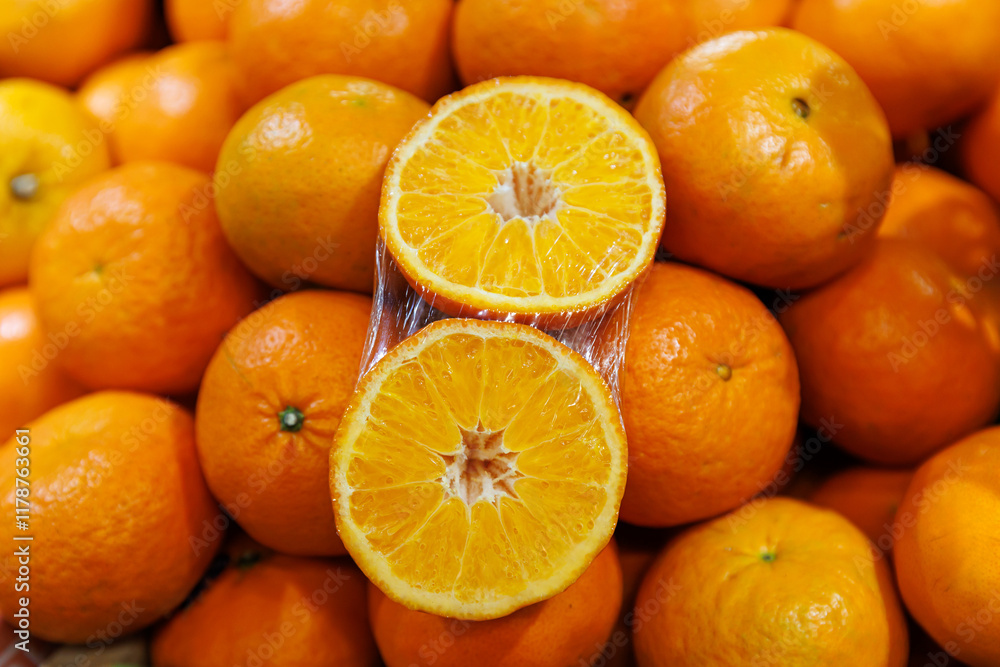 Close-up of freshly harvested oranges, showcasing a vibrant display of whole fruits and a halved orange revealing juicy, succulent segments, symbolizing freshness, health, and natural sweetness Close-up of freshly harvested oranges, showcasing a vibrant display of whole fruits and a halved orange revealing juicy, succulent segments, symbolizing freshness, health, and natural sweetness