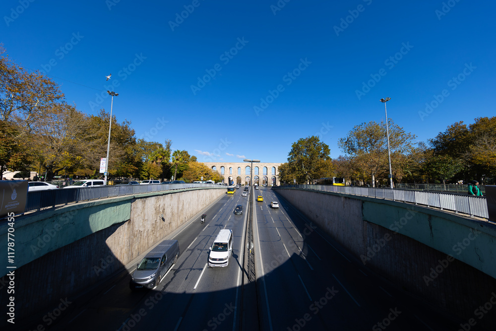Traffic in Ataturk boulevard with view of Valens Aqueduct in background. Cloudy autumn view.