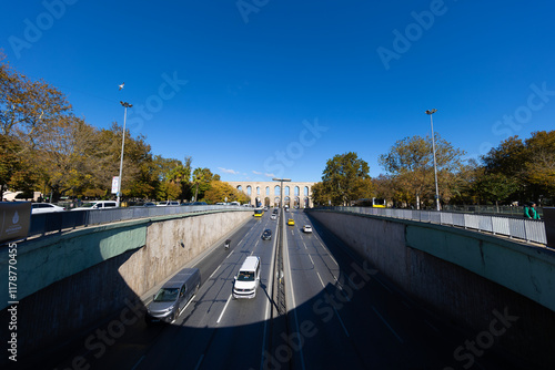Traffic in Ataturk boulevard with view of Valens Aqueduct in background. Cloudy autumn view.