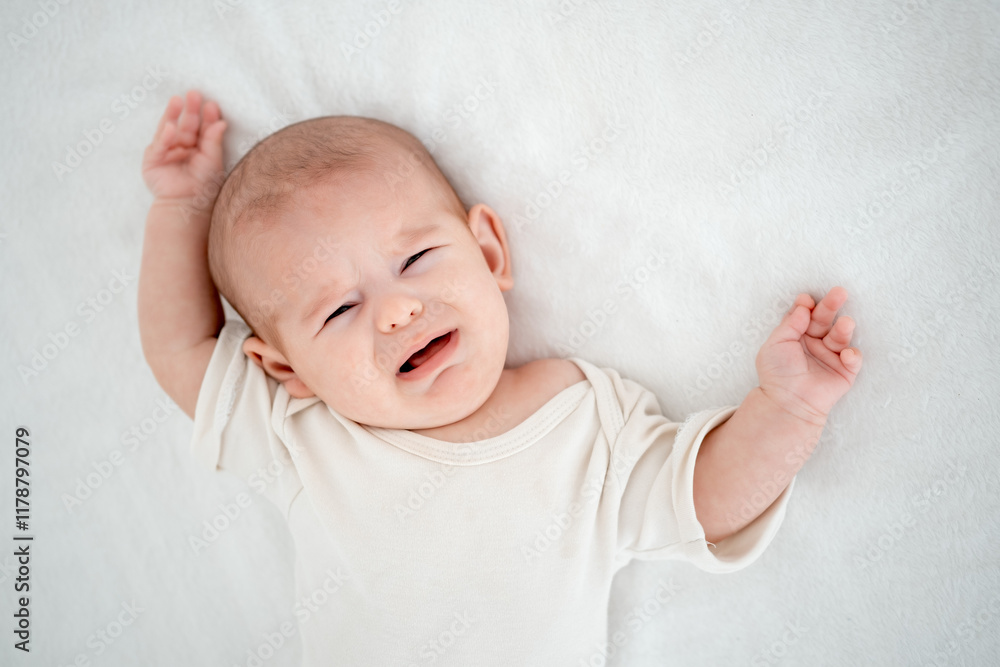 crying baby, newborn baby calling for mom, crying and screaming on a white bed at home, space for text