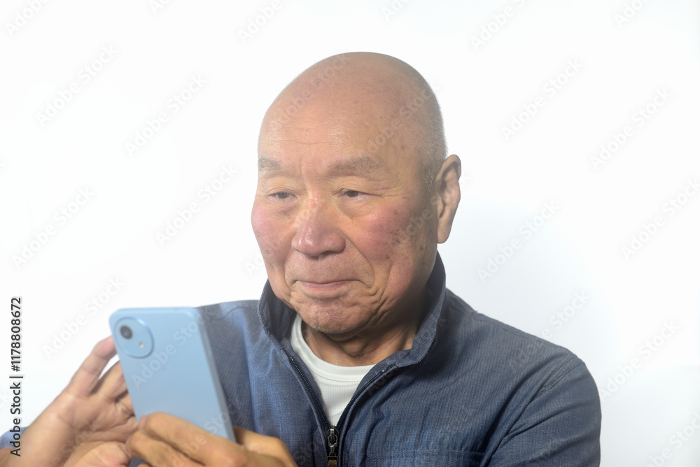 笑顔でスマートフォンを操作する老人 笑顔でスマートフォンを操作する老人