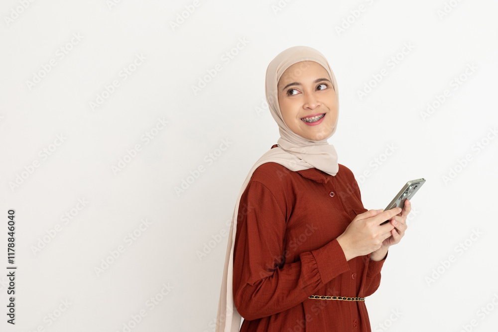 Young Woman Smiling While Holding a Smartphone in Casual Attire Young Woman Smiling While Holding a Smartphone in Casual Attire