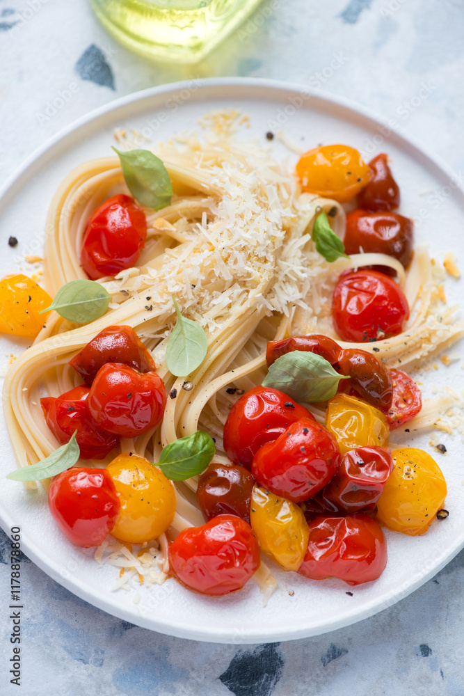 Linguine with roasted cherry tomatoes, grated cheese and basil, vertical shot, selective focus, middle close-up Linguine with roasted cherry tomatoes, grated cheese and basil, vertical shot, selective focus, middle close-up