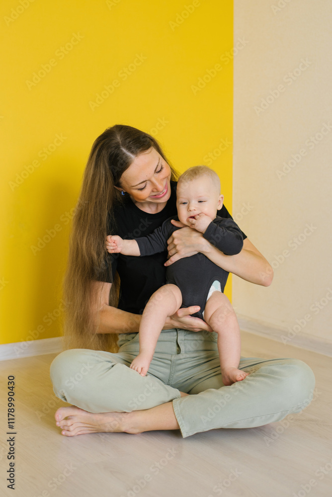 Happy mother is holding a baby in her arms at home. Scene is warm and loving Happy mother is holding a baby in her arms at home. Scene is warm and loving