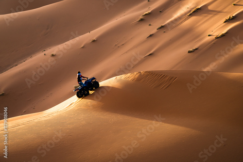 Quad on the sand dunes in the Sahara desert, Merzouga, Morocco photo