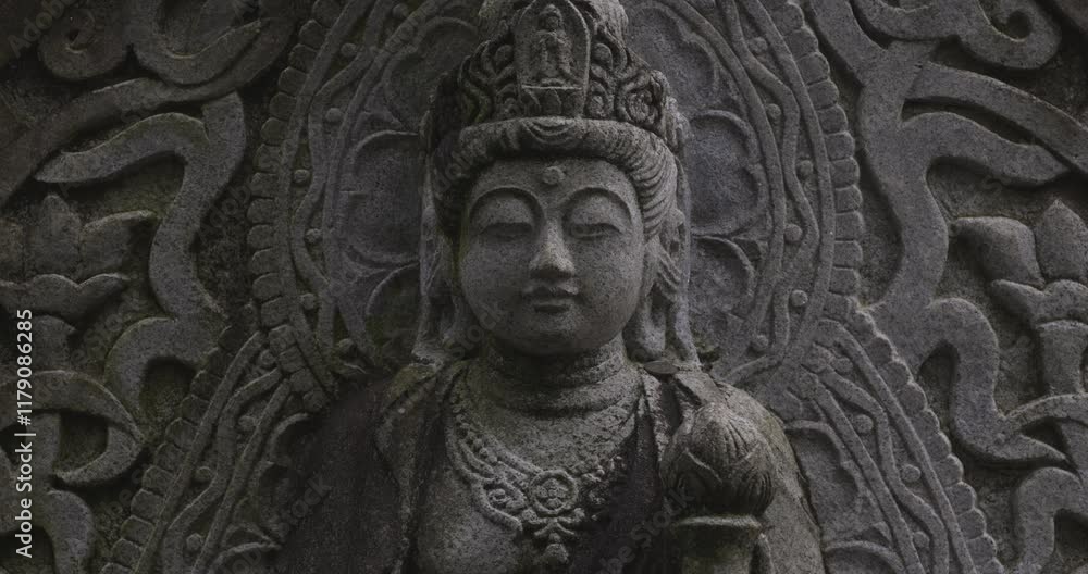 A religious stone statue of Kannon at Japanese buddhism temple A religious stone statue of Kannon at Japanese buddhism temple