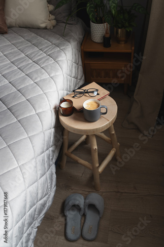 winter home aestetics with  coffee and candle on wooden stool. Modern grey and beige bedroom photo