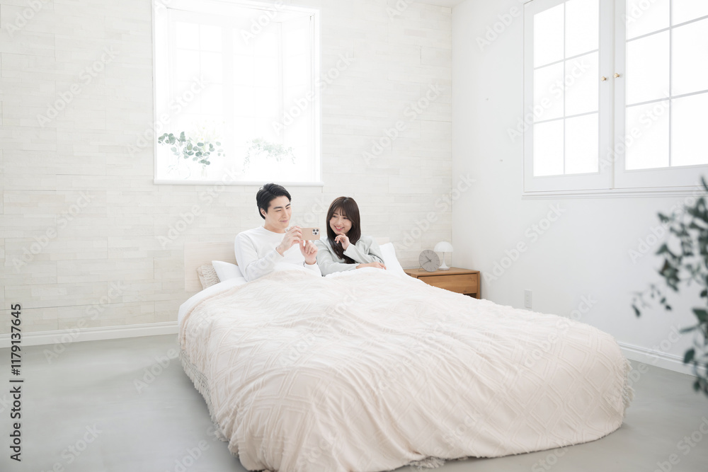 綺麗なベッドルームでくつろぐ新婚のようなカップル 広角 綺麗なベッドルームでくつろぐ新婚のようなカップル 広角