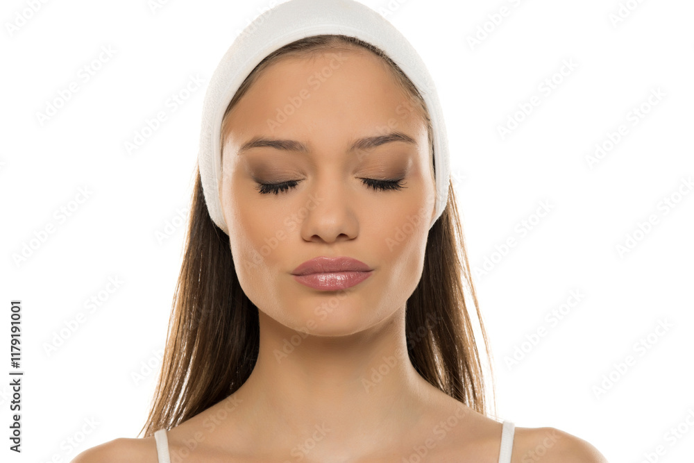 Headshot of a young woman with makeup and scarf on a white studio background. Eyes closed Headshot of a young woman with makeup and scarf on a white studio background. Eyes closed