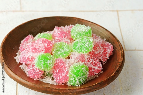 Traditional Indonesian cenil or gurandil served on a traditional plate with banana leaves. Colorful tapioca balls coated in grated coconut create a visually appealing and delicious traditional snack. photo