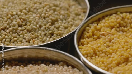 Different types of millets in stored in steel bowls, 4k, close up, push in shot photo