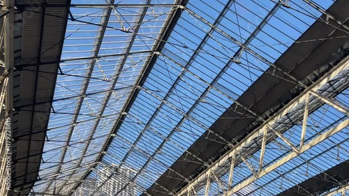 Wallpaper Mural Wide-angle view of the intricate glass and steel roof structure at Waterloo Station in London, showcasing its architectural details under a bright blue sky. Torontodigital.ca