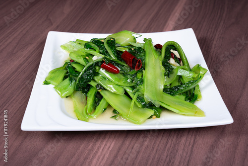 Stir-fried vegetable lettuce tips on a white plate photo