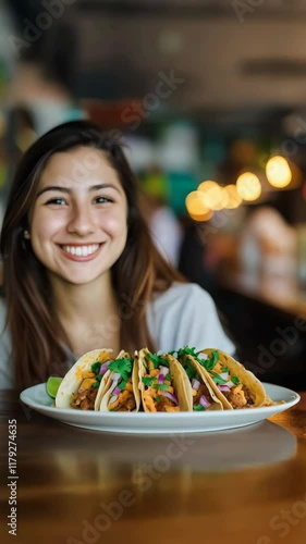 Wallpaper Mural Young Latin American woman smiling sitting with a plate of tacos in an urban bar Torontodigital.ca