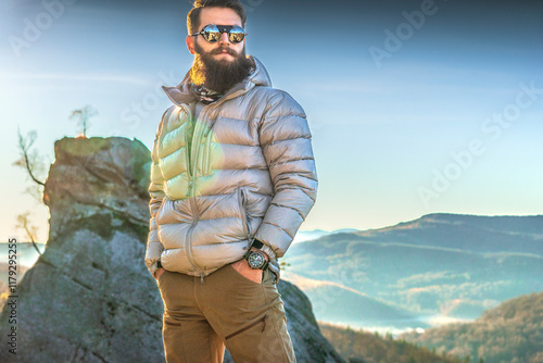 Male hiker arrives at crest of sunny mountain ridge. Forest and hills distant, aspen trees in autumntime photo