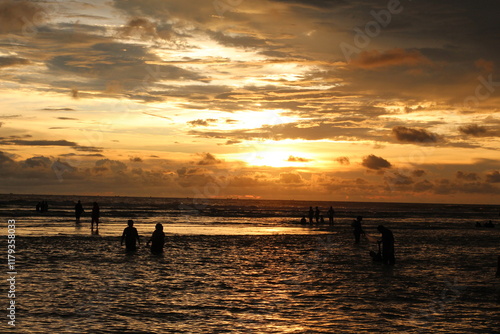 Wallpaper Mural Silhouette people man a woman on the sunset background, mSunset on the tropical beach Seminyak. The tourists watching for beautiful sunset in the sea. Coast of the sea at colorful sunset. Torontodigital.ca