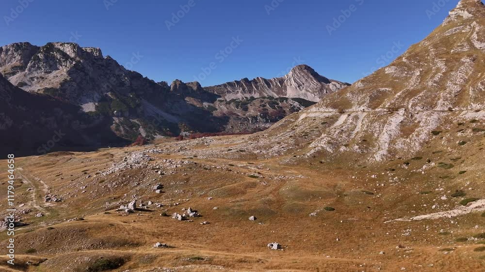 Aerial journey over rugged mountainous valley under clear blue sky Aerial journey over rugged mountainous valley under clear blue sky