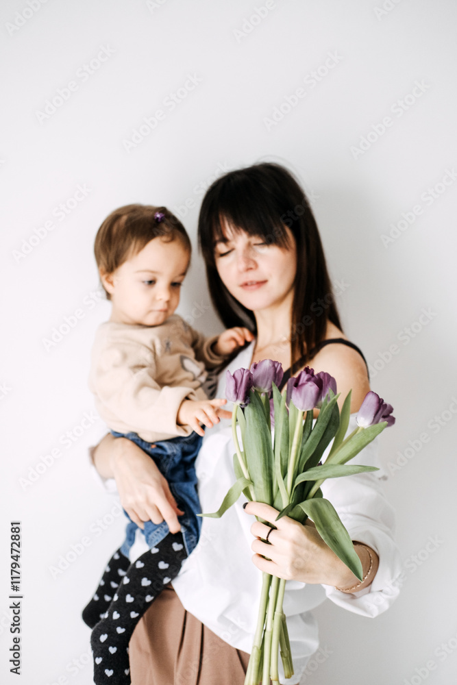 Mother and child admiring purple tulips. Real-life family moments, Mother's Day celebration, natural parenting, authentic connection, childhood curiosity. Mother and child admiring purple tulips. Real-life family moments, Mother's Day celebration, natural parenting, authentic connection, childhood curiosity.
