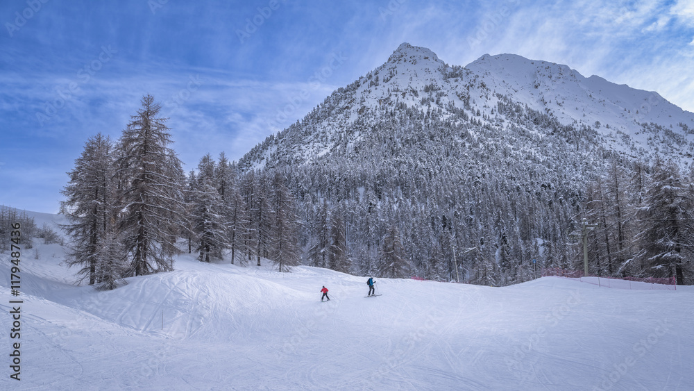 Naklejka premium This picturesque winter landscape features snowy mountains and enthusiastic skiers, making it an ideal destination for outdoor adventures, Montgenevre ski village, Alps, France