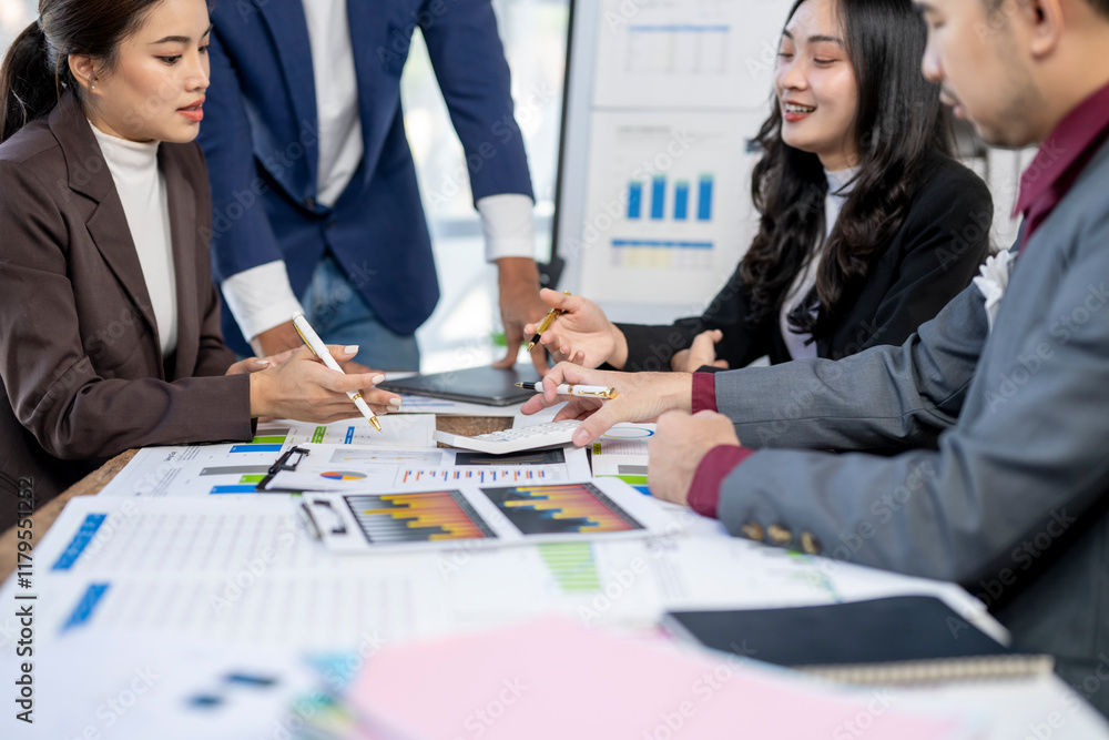 A group of people are sitting around a table with papers and graphs A group of people are sitting around a table with papers and graphs