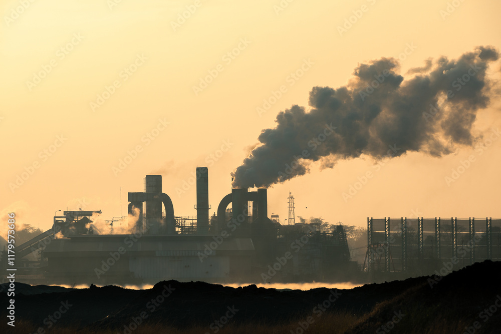 Silhouette of smoke from sugar mill chimneys at sunrise, causing air pollution Silhouette of smoke from sugar mill chimneys at sunrise, causing air pollution