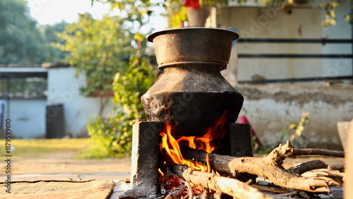 Outdoor Indian earthen cooking stove Countryside stove or Chulha or clay stove with a black colored circular vessel on it, photo