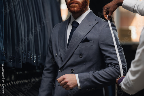 Obraz na płótnie Luxury designer atelier, professional tailor measuring customer for bespoke suit