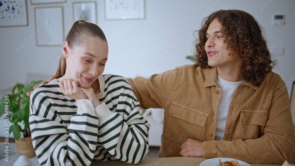 Smiling spouses kissing apartment table having romantic home breakfast closeup. Smiling spouses kissing apartment table having romantic home breakfast closeup.