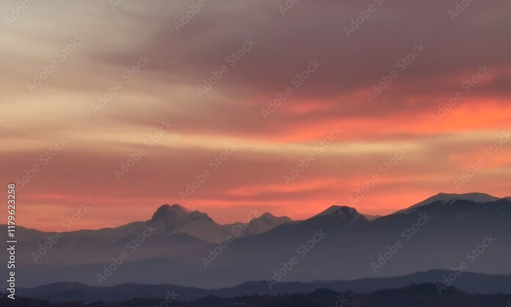 Fototapeta premium Nuvole rosse tramonto sopra le montagne 