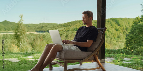 Obraz na plátně Freelancer works online on the terrace of a country house, enjoying nature and a beautiful forest view
