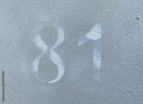 White number 81 on gray background. Eighty-first on textured surface  photo