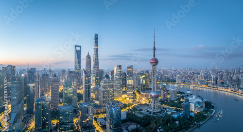 Fototapeta Naklejka Na Ścianę i Meble -  Panoramic view of a modern city skyline with iconic tower and illuminated buildings at twilight in Shanghai